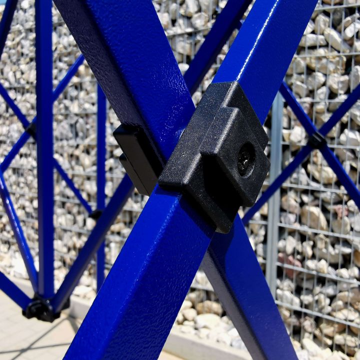 Detalje af den sorte plastforbindelsesdel på den blå metalstruktur (stænger) af teltet.